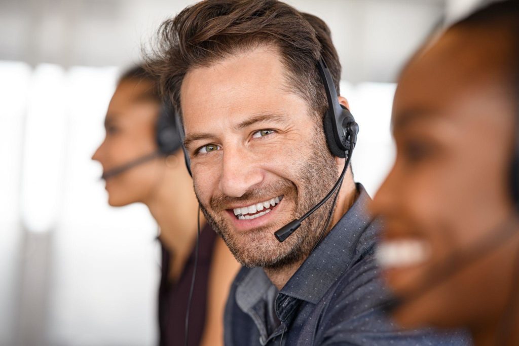 Portrait of happy mature customer service man on call